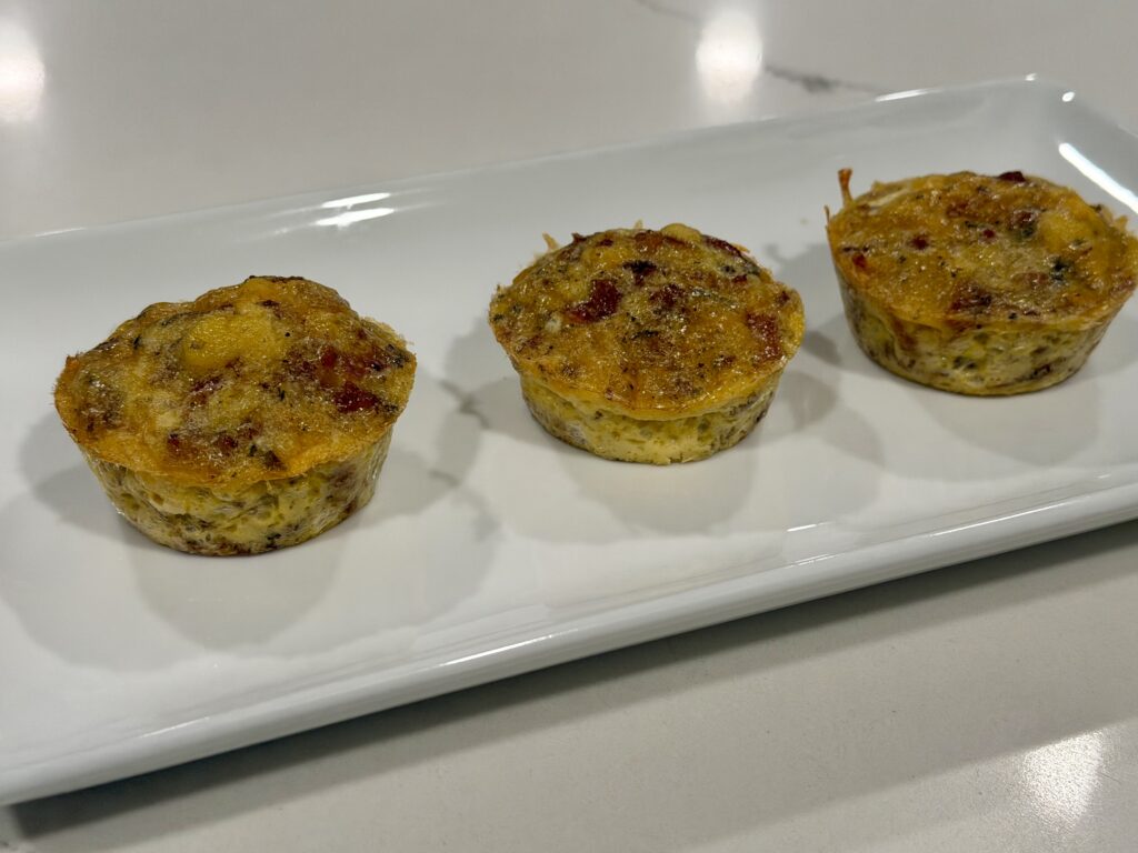 Homemade bacon sausage and cheese egg bites plated on a white serving dish from Reynaldo’s Cocina.