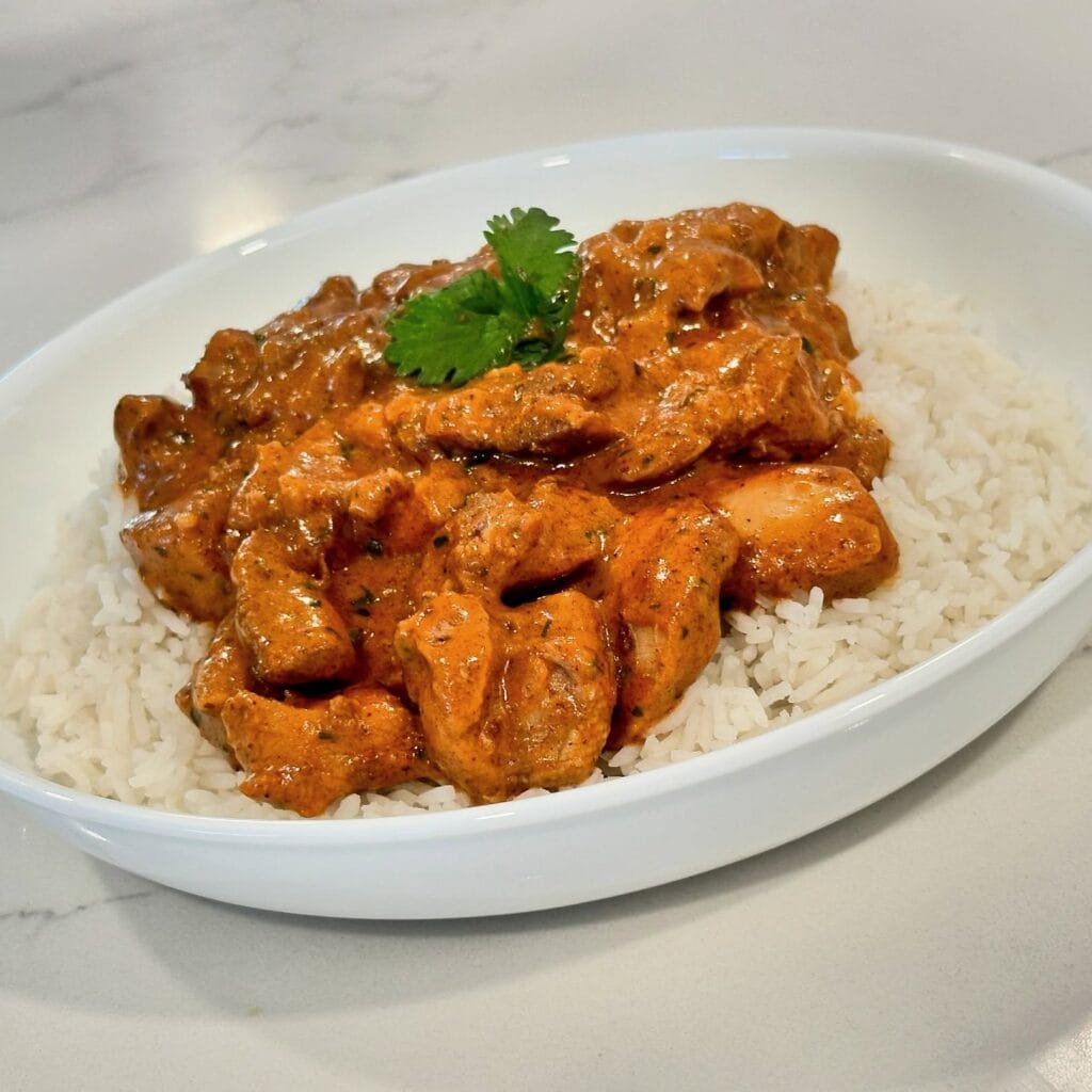 Butter Chicken Reynaldos Cocina Homemade butter chicken served over basmati rice with rich creamy tomato sauce and fresh cilantro.