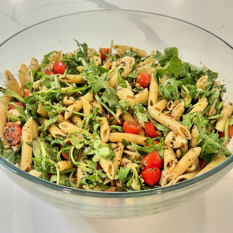 Caprese pasta salad with rotini pasta, cherry tomatoes, fresh mozzarella, arugula, basil, pine nuts, Parmesan, and balsamic glaze.