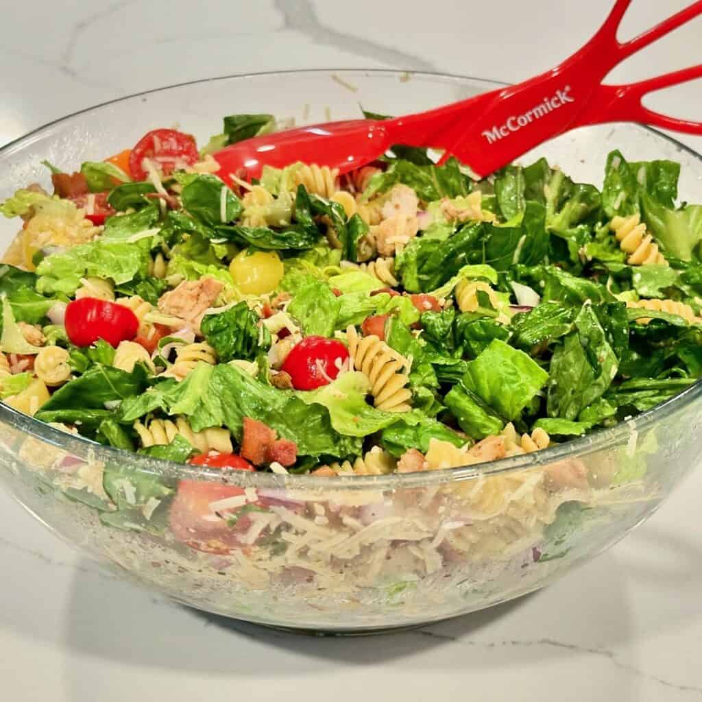 Chicken Caesar Pasta Salad Reynaldos Cocina Chicken Caesar pasta salad with grilled chicken, romaine lettuce, rotini pasta, bacon, cherry tomatoes, red onion, and Parmesan cheese.