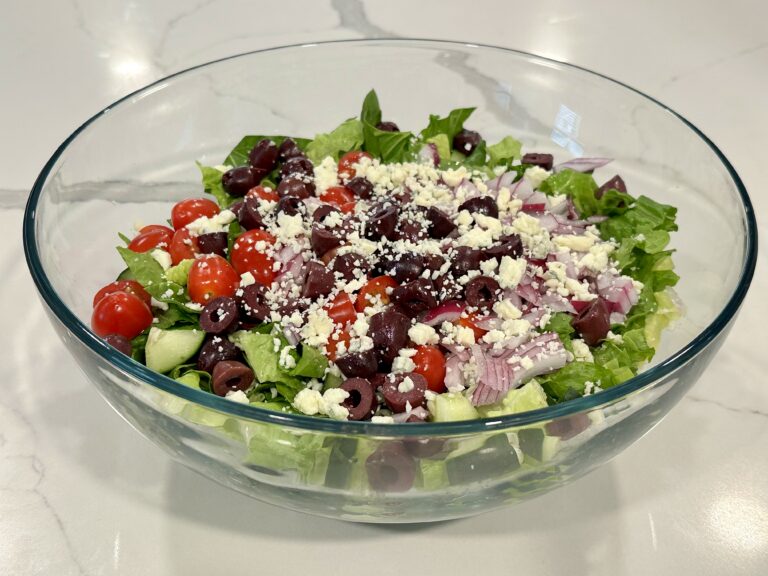 Greek Salad with romaine lettuce, cucumbers, cherry tomatoes, red onion, kalamata olives, feta cheese, and homemade vinaigrette.