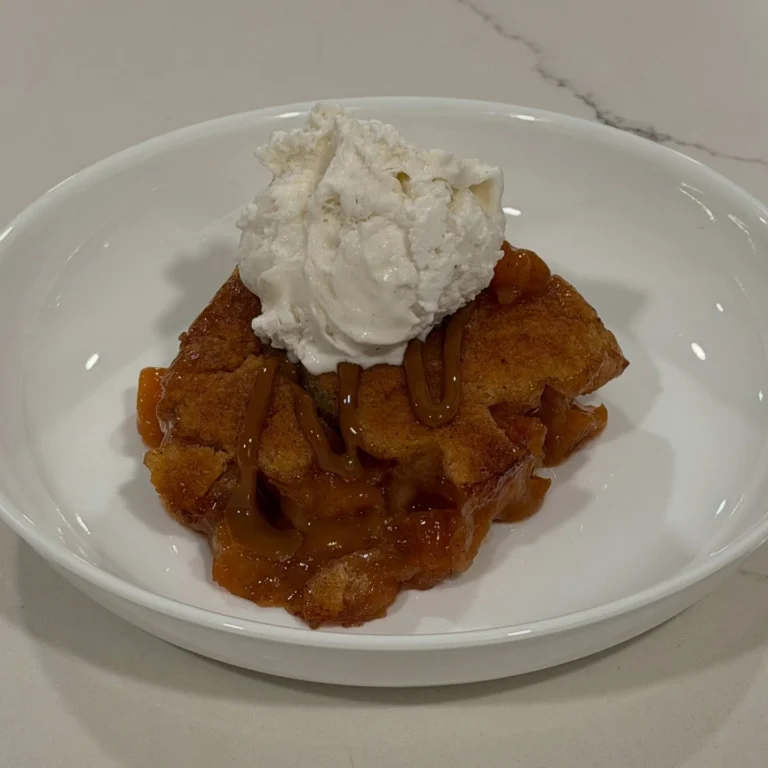Homemade peach cobbler baked until golden and finished with caramel drizzle and French vanilla ice cream.