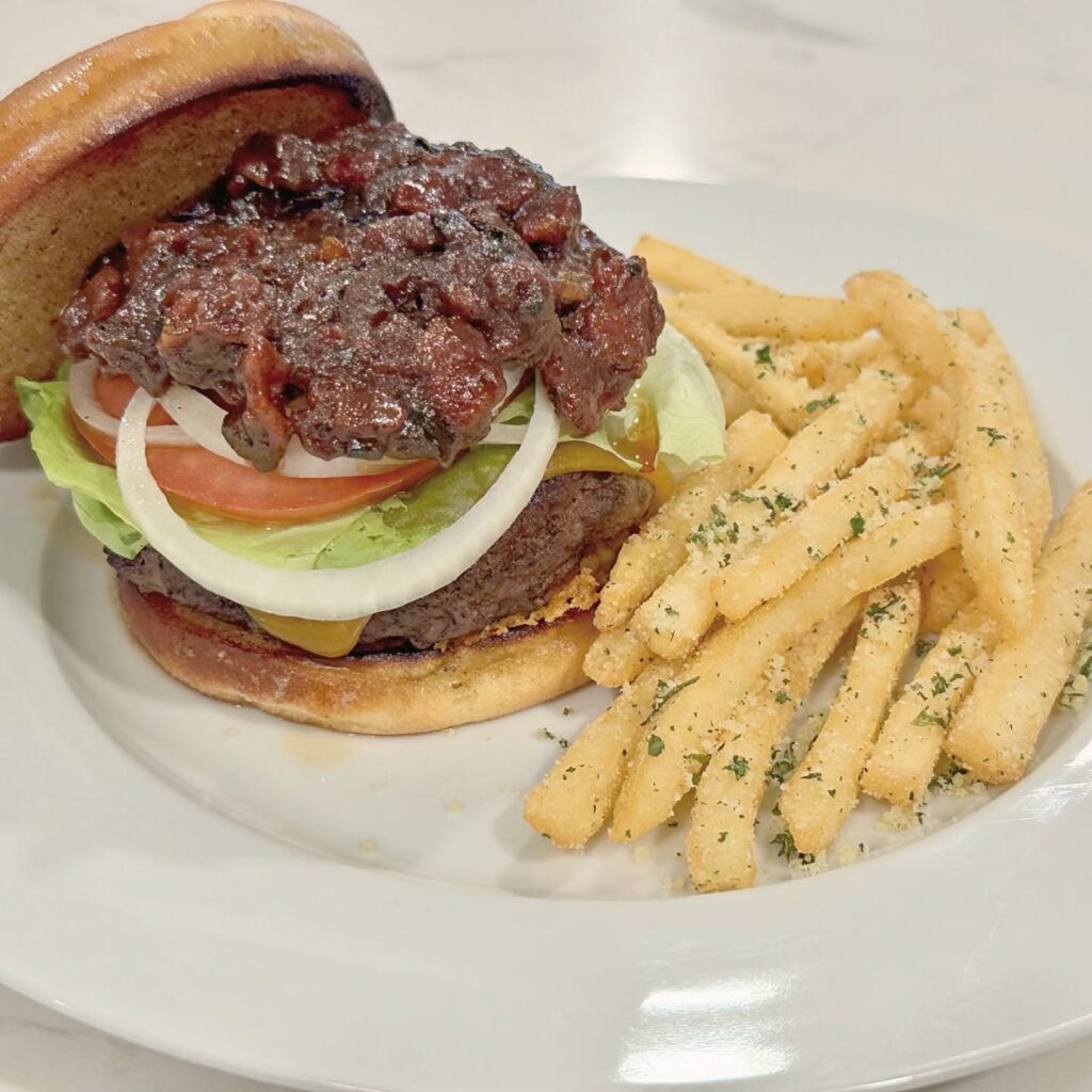 Kobe beef cheeseburger with bacon jam, cheddar, lettuce, tomato, onion, and garlic Parmesan fries.