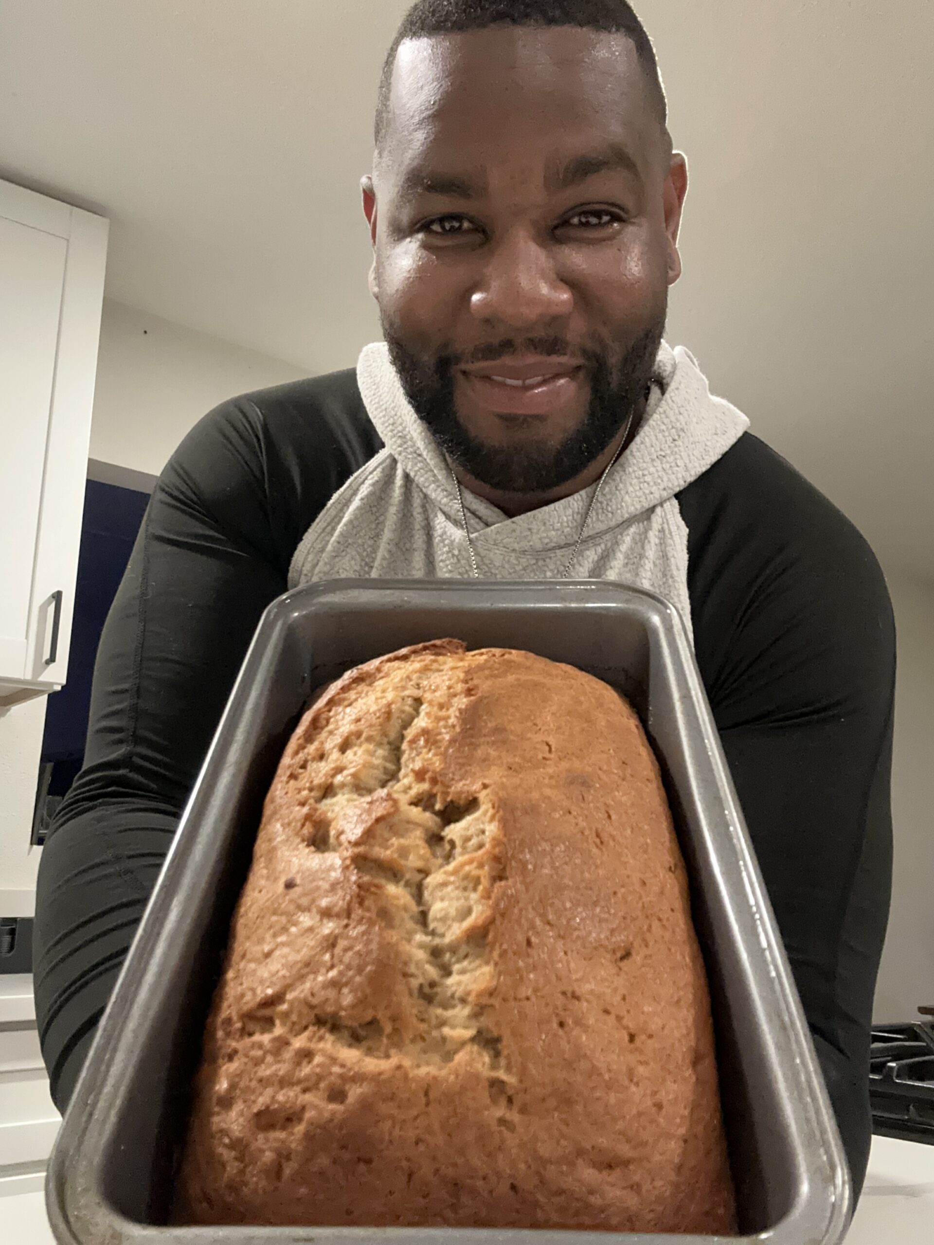 Reynaldo Stephens holding homemade banana bread in the kitchen for Reynaldo’s Cocina.