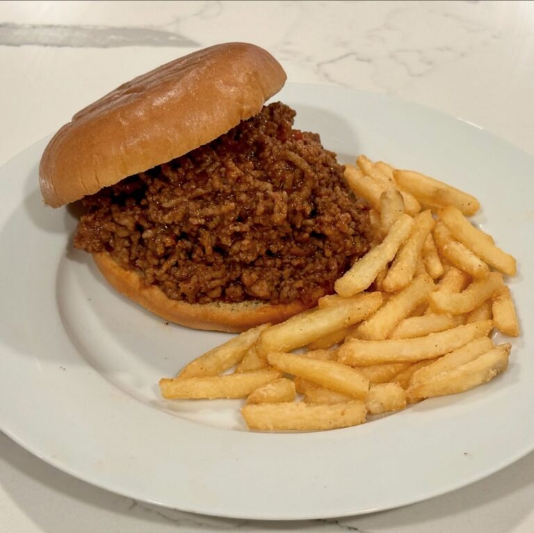 Homemade Sloppy Joe sandwich piled high with rich seasoned ground beef on a toasted bun served with crispy fries.