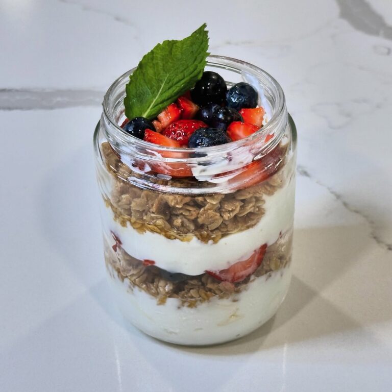 Summer berry parfait layered with Greek yogurt, honey granola, fresh strawberries, blueberries, blackberries, and mint.