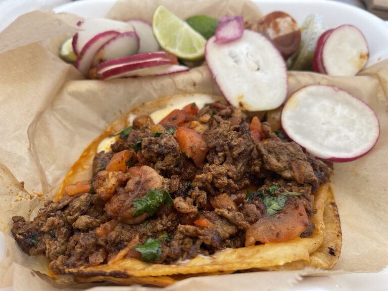 Surf and turf taco with steak shrimp cilantro and radish on handmade tortilla by Reynaldo’s Cocina
